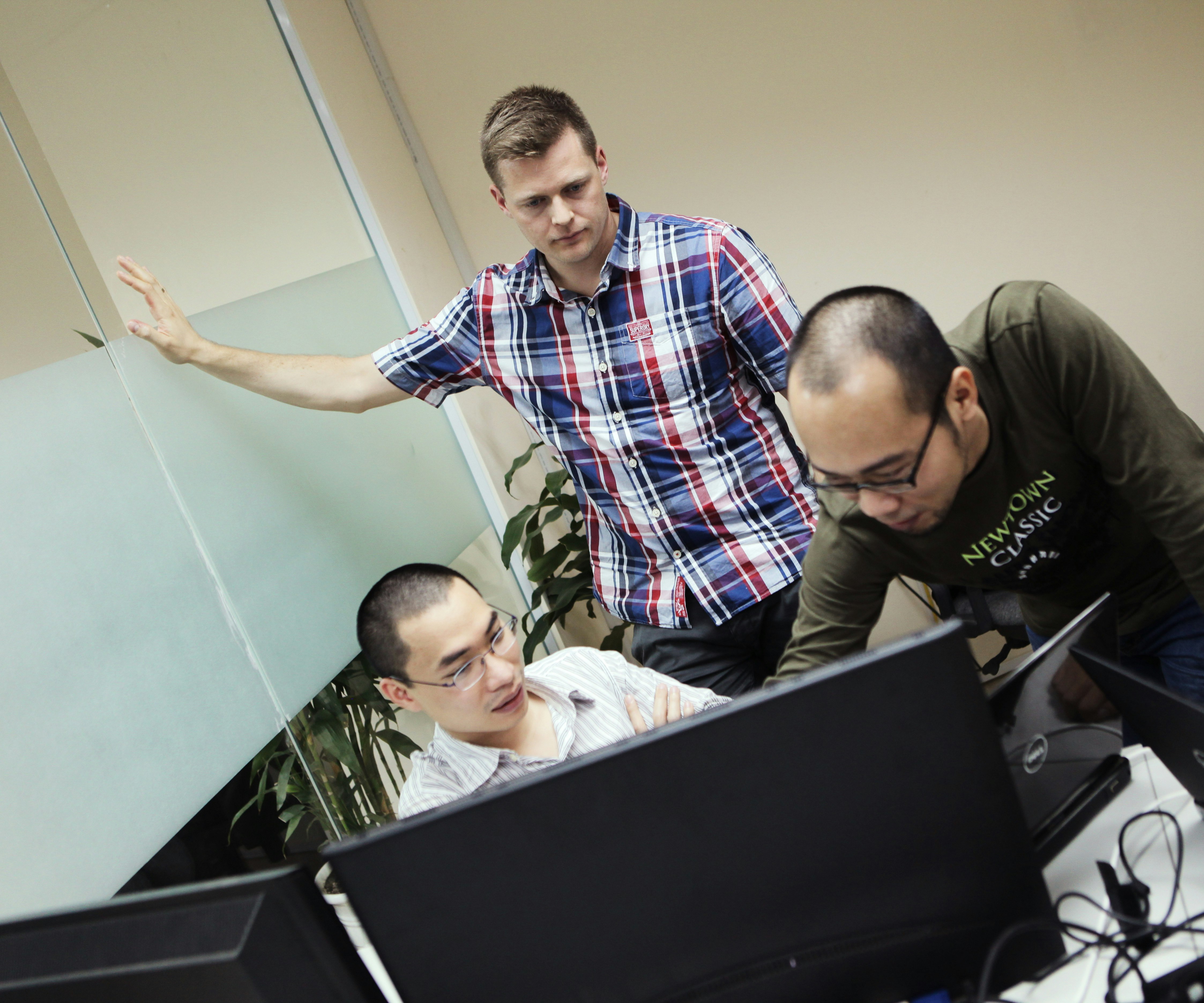 Tejs and Khanh making plans Three image editing API developers conferencing on solutions in front of computer